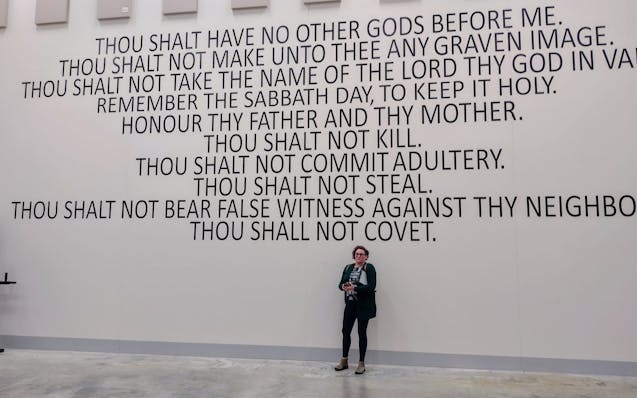 Grand Rapids resident Dana Butler stands beneath the 10 Commandments painted on the wall of the new Itasca County jail.
