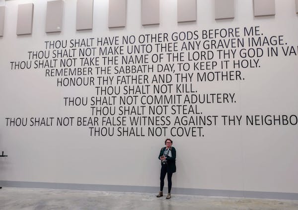 Grand Rapids resident Dana Butler stands beneath the 10 Commandments painted on the wall of the new Itasca County jail.
