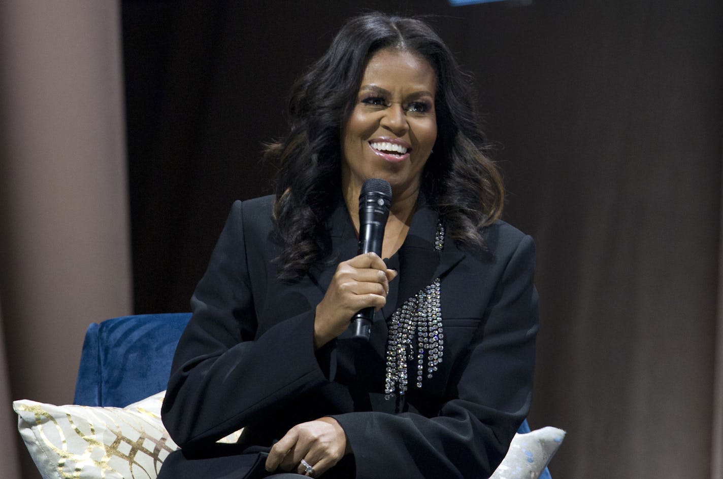 Michelle Obama speaks to the crowd as she presents her anticipated memoir "Becoming" during her book tour stop in Washington, Saturday, Nov. 17, 2018. (AP Photo/Jose Luis Magana)