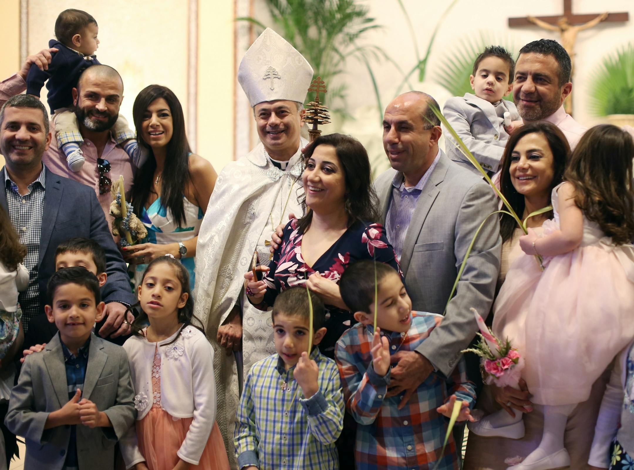 Pastor Sharbel-Ghattas Maroun posed for photos with church members after Palm Sunday services at Maron's Catholic Church March 20, 2016 in Minneapolis MN.