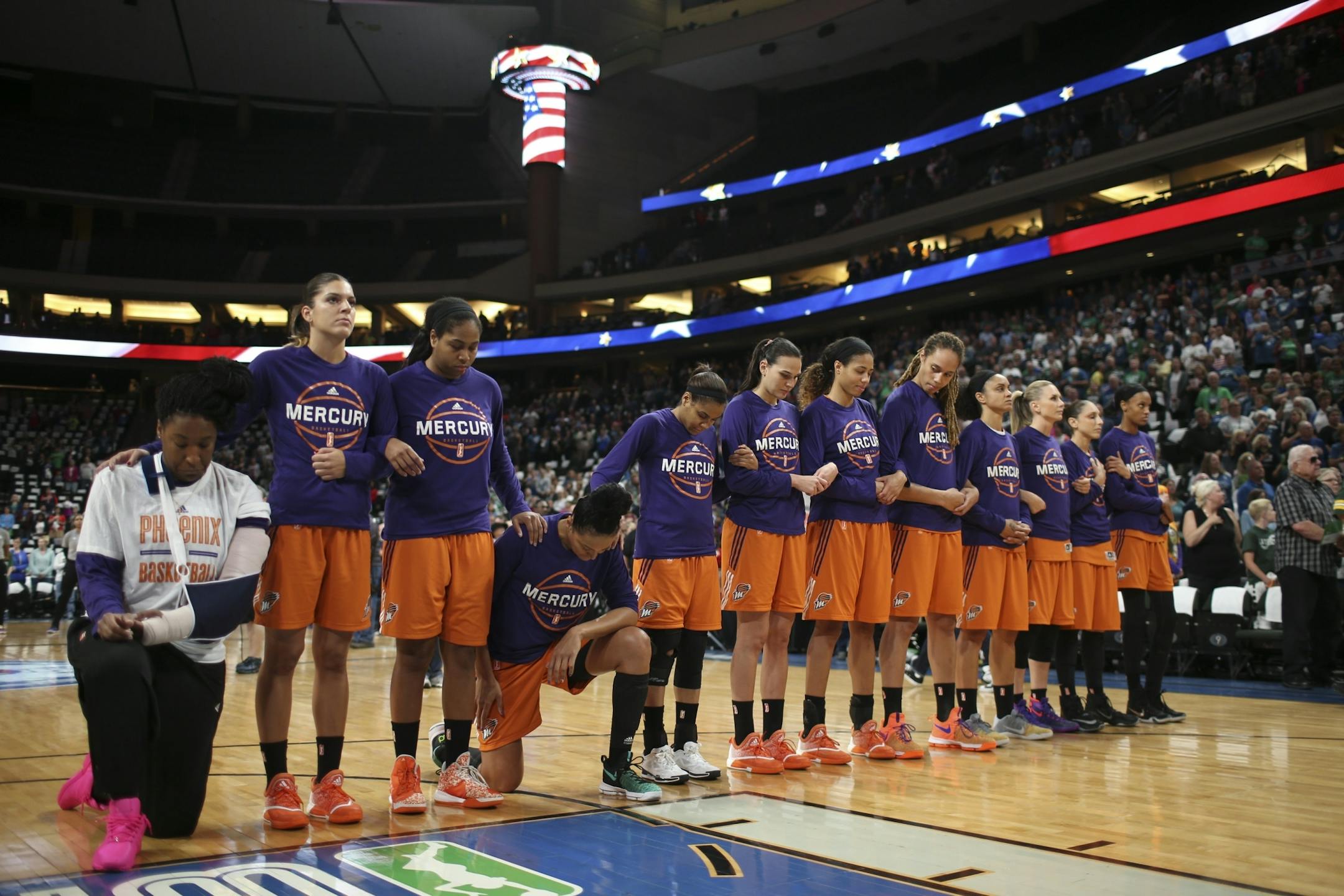 Phoenix Mercury center Kelsey Bone, left, and forward Mistie Bass (8) knelt with their team during the national anthem..