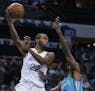 Minnesota Timberwolves forward Andrew Wiggins (22) passes the ball over Charlotte Hornets guard Dwayne Bacon during the second half of an NBA basketba