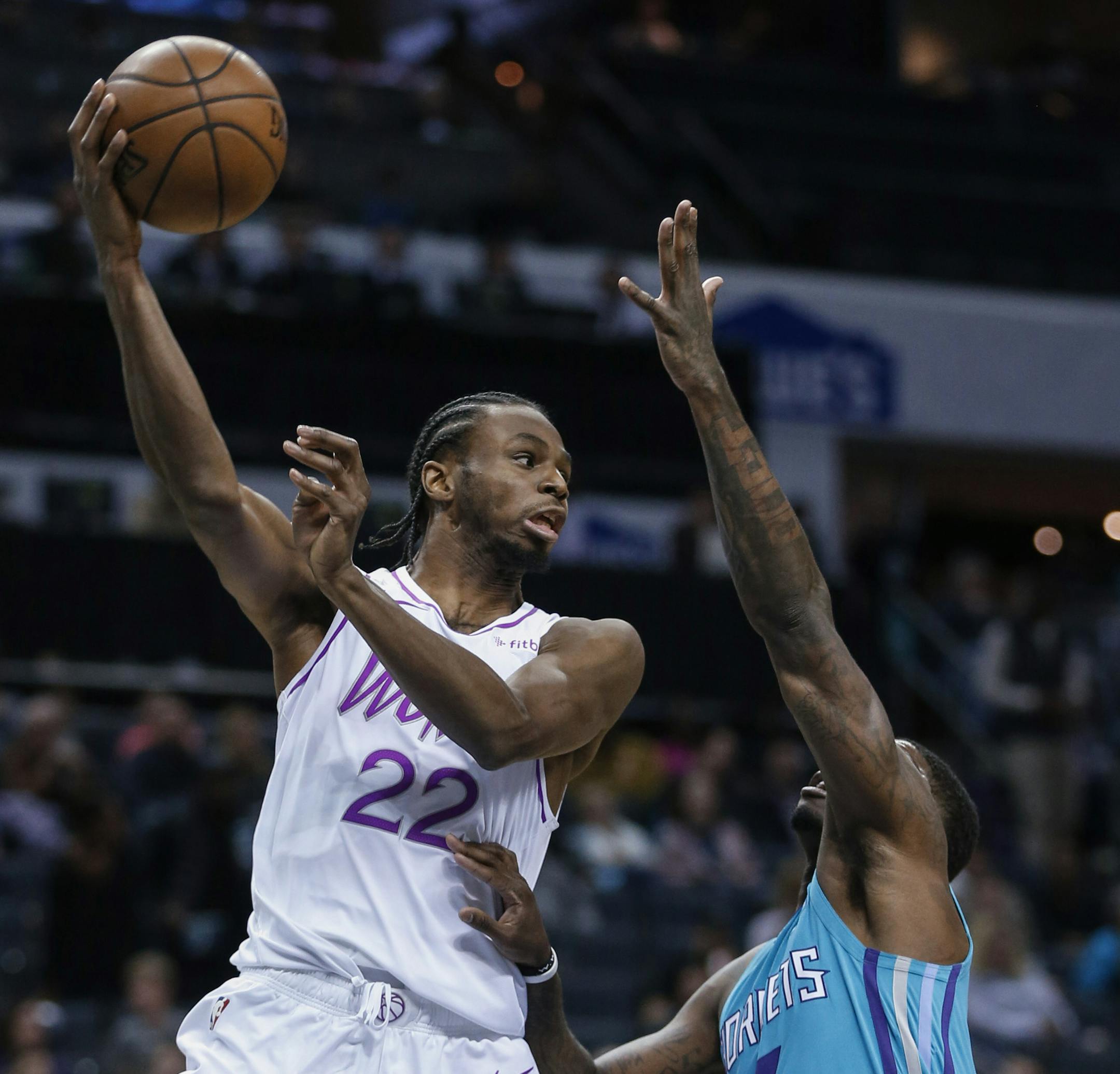Minnesota Timberwolves forward Andrew Wiggins (22) passes the ball over Charlotte Hornets guard Dwayne Bacon during the second half of an NBA basketball game in Charlotte, N.C., Thursday, March 21, 2019. Charlotte won 113-106. (AP Photo/Nell Redmond)