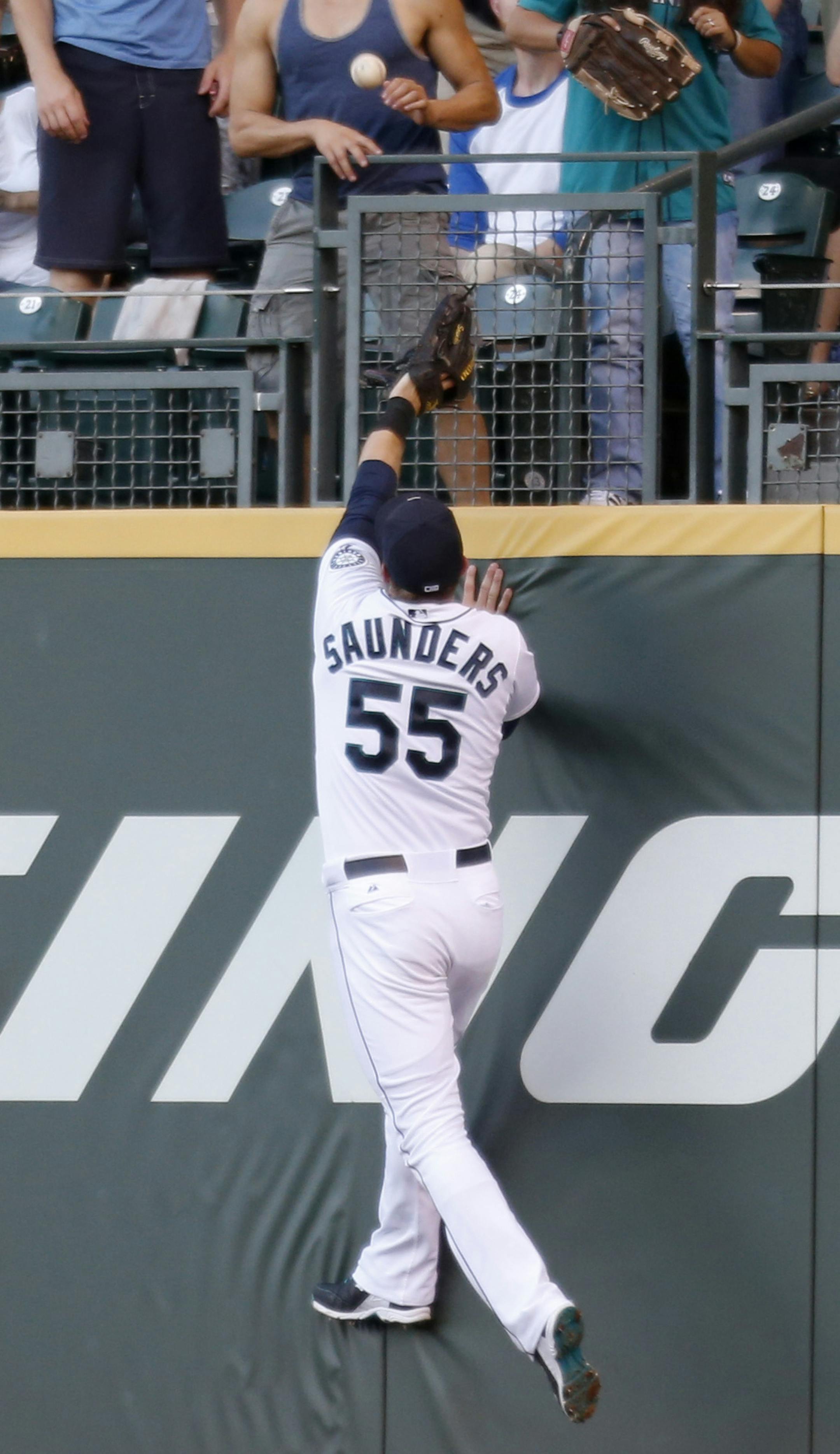 Seattle Mariners right fielder Michael Saunders leaps after the home run ball hit by Minnesota Twins' Sam Fuld during the fifth inning of a baseball game on Tuesday, July 8, 2014 in Seattle. (AP Photo/John Froschauer)