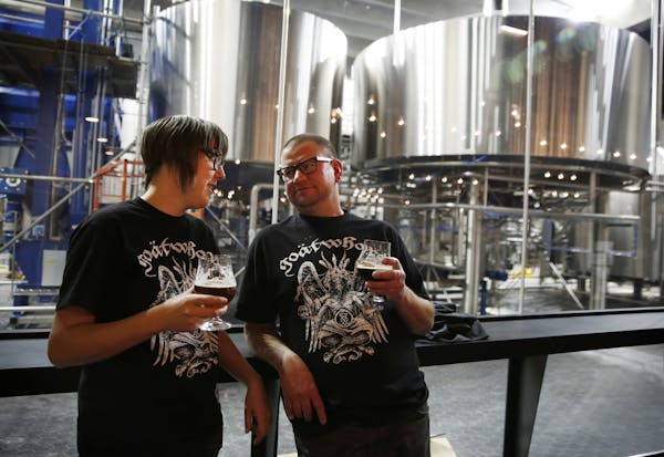 Bartender Amy "Scar" Ronning, left, and cellar master Michael Nelson chat and drink beer during an employee walk-through of Surly Brewing Co.'s new de