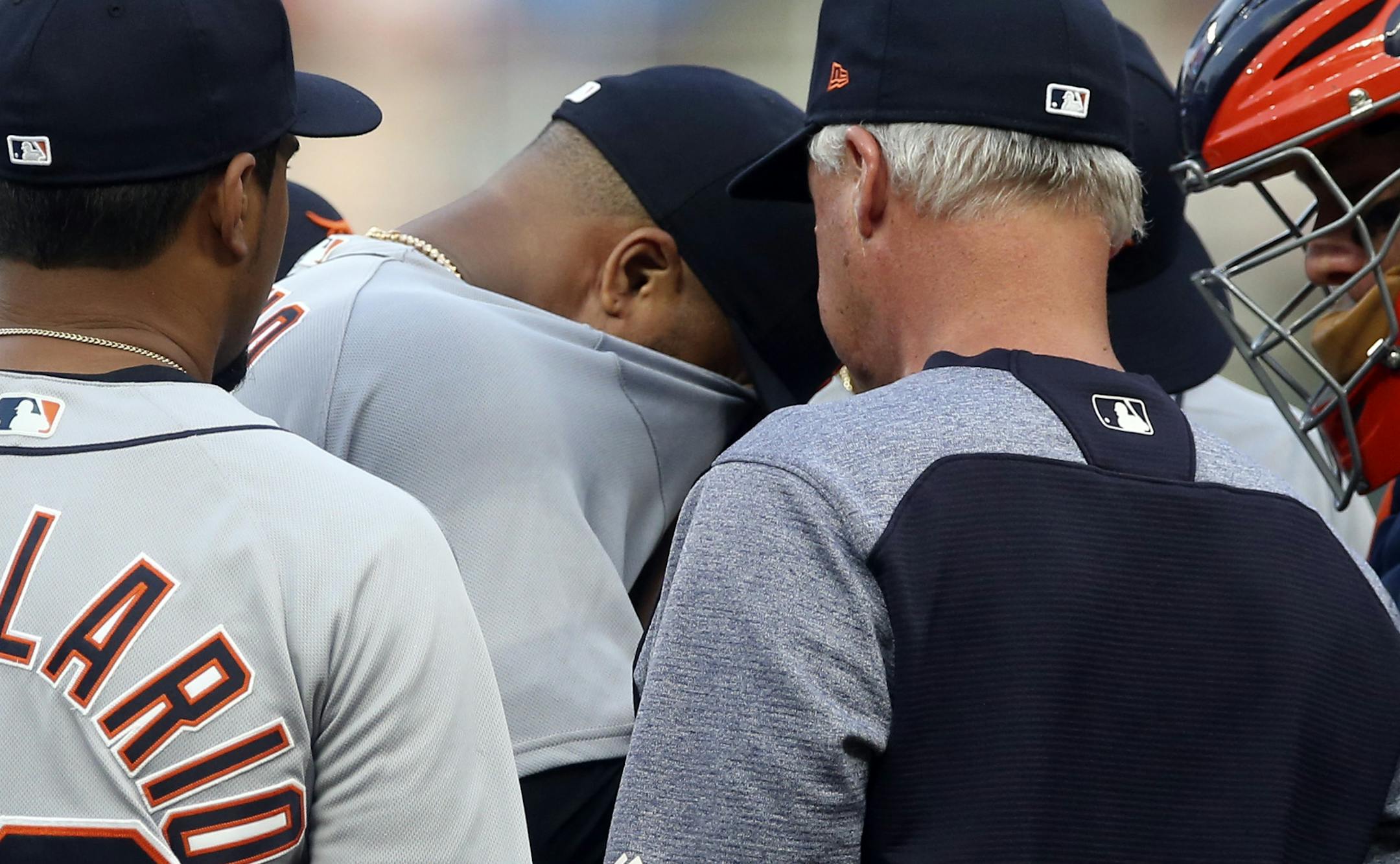 Detroit Tigers pitcher Francisco Liriano, center, wipes his face as he gets a mound visit from pitching coach Rick Anderson during the first inning of a baseball game Thursday, Aug. 16, 2018, in Minneapolis. Liriano gave up a three-run home run in the first and was pulled in the second inning after giving up another home run. (AP Photo/Jim Mone)