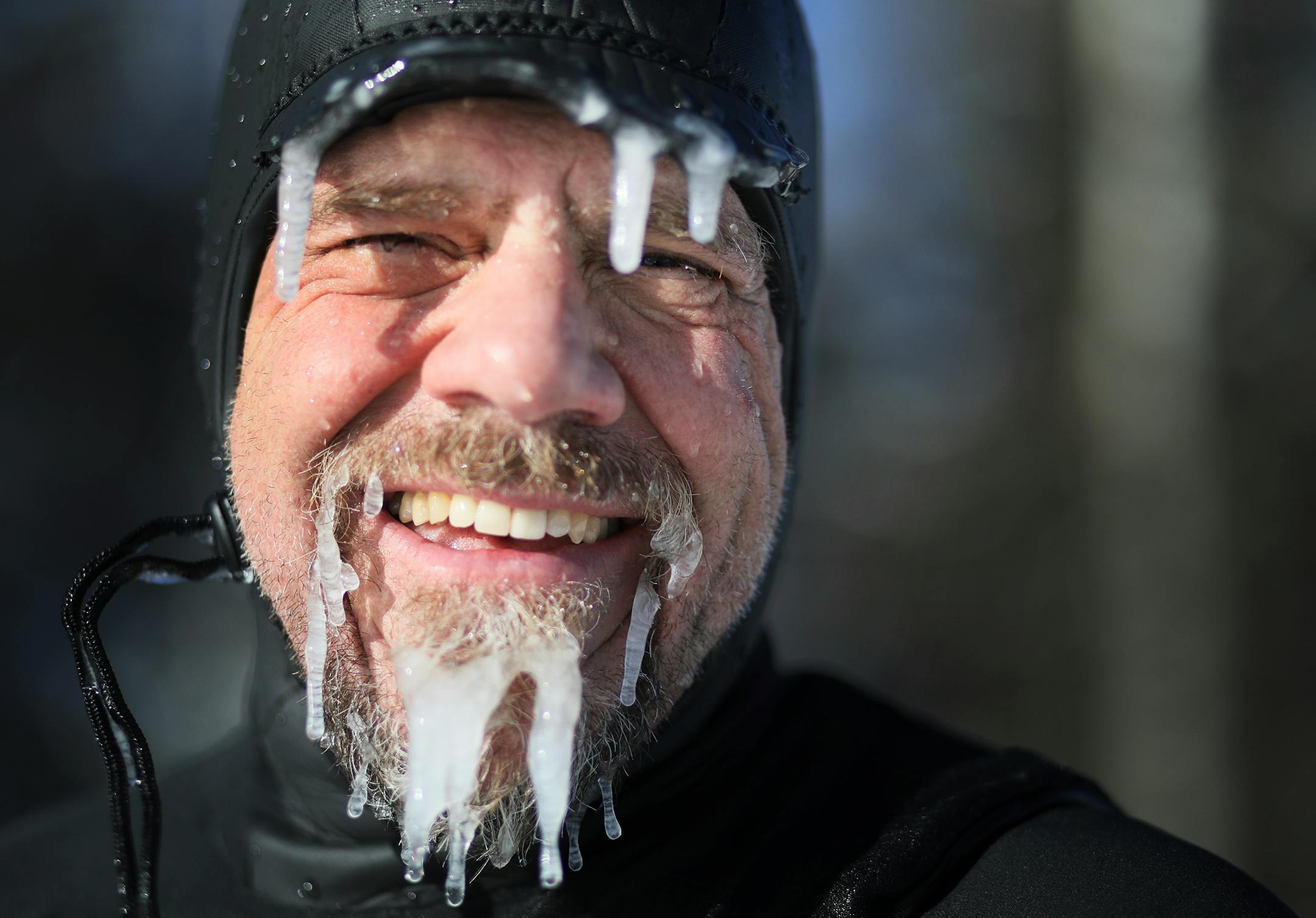 Surfer Randy Carlson of Duluth, Minn., is coated in ice but happy after riding waves on New Year's Day on Stoney Point, Tuesday, January 1, 2019 in Two Harbors, Minn.