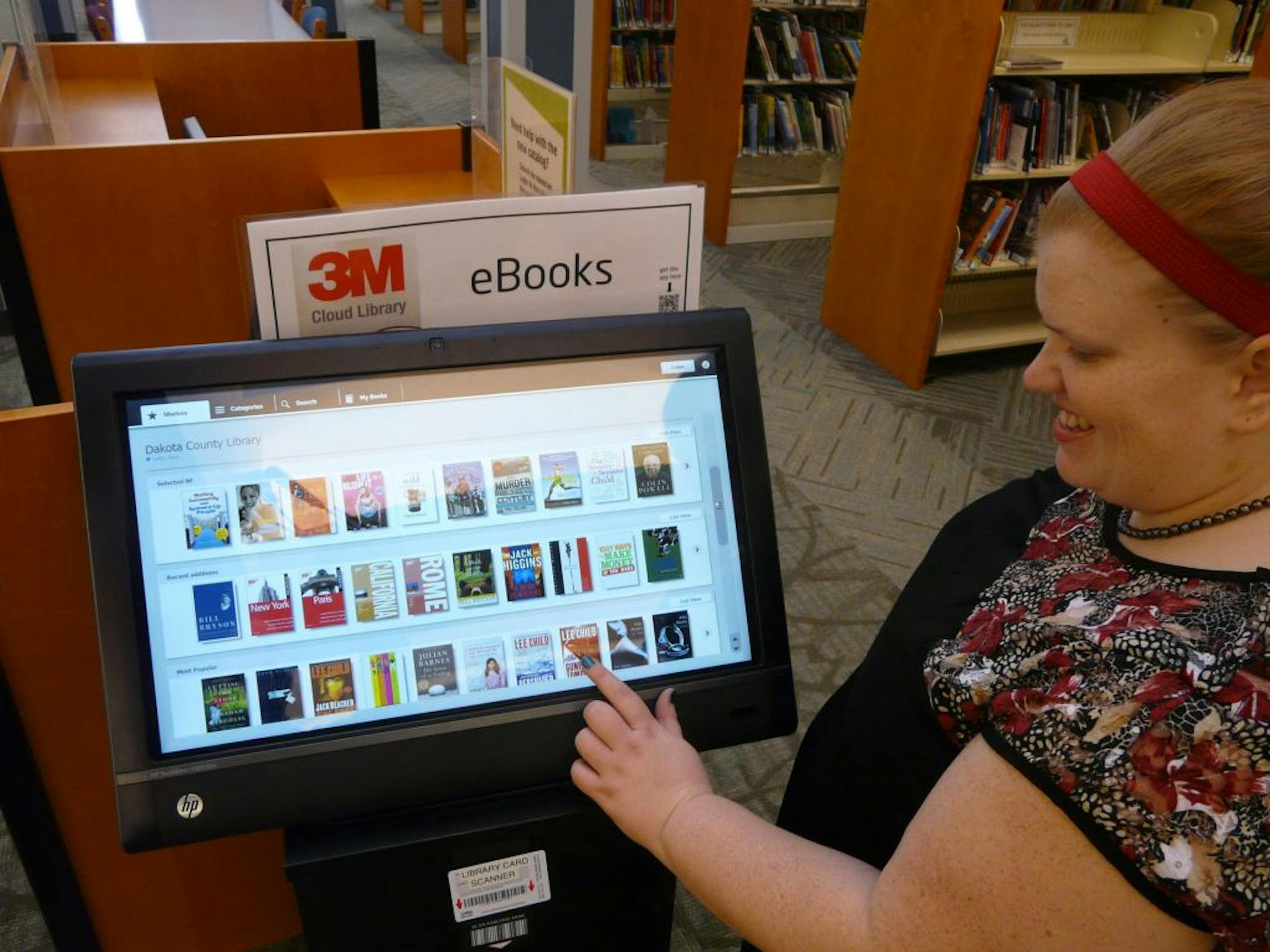 Dakota County librarian Deborah Monn, who works at the system's branch in Burnsville, points out features of the 3M Cloud Library terminal installed in branches around the county. The library system is still building its collection of e-books, so patrons may find some genres are still thinly represented.