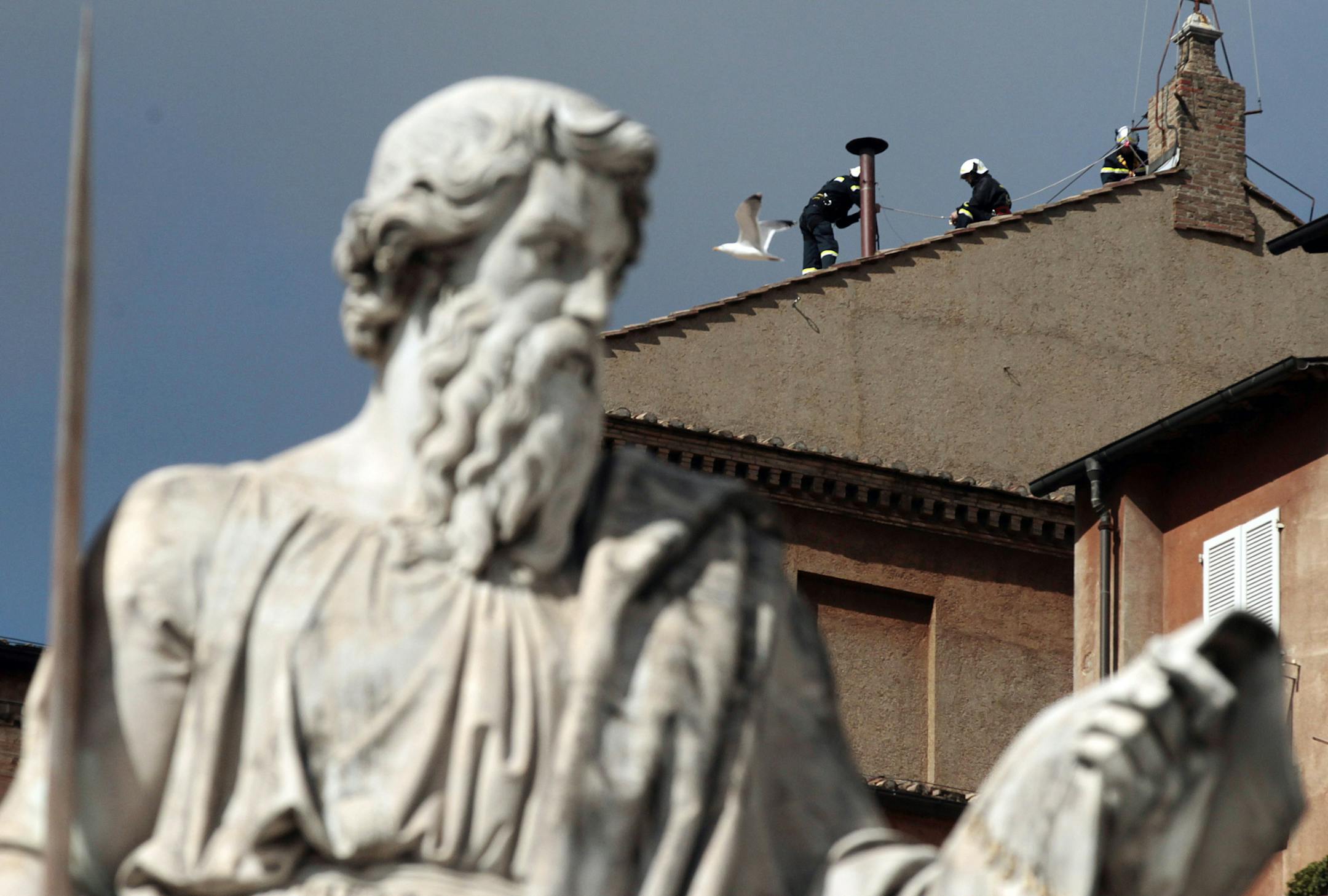 Firefighters place the chimney on the roof of the Sistine Chapel, where cardinals will gather to elect the new pope, at the Vatican, Saturday, March 9, 2013. The preliminaries over, Catholic cardinals are ready to get down to the real business of choosing a pope. And even without a front-runner, there are indications they will go into the conclave Tuesday with a good idea of their top picks. The conclave date was set Friday during a vote by the College of Cardinals, who have been meeting all wee
