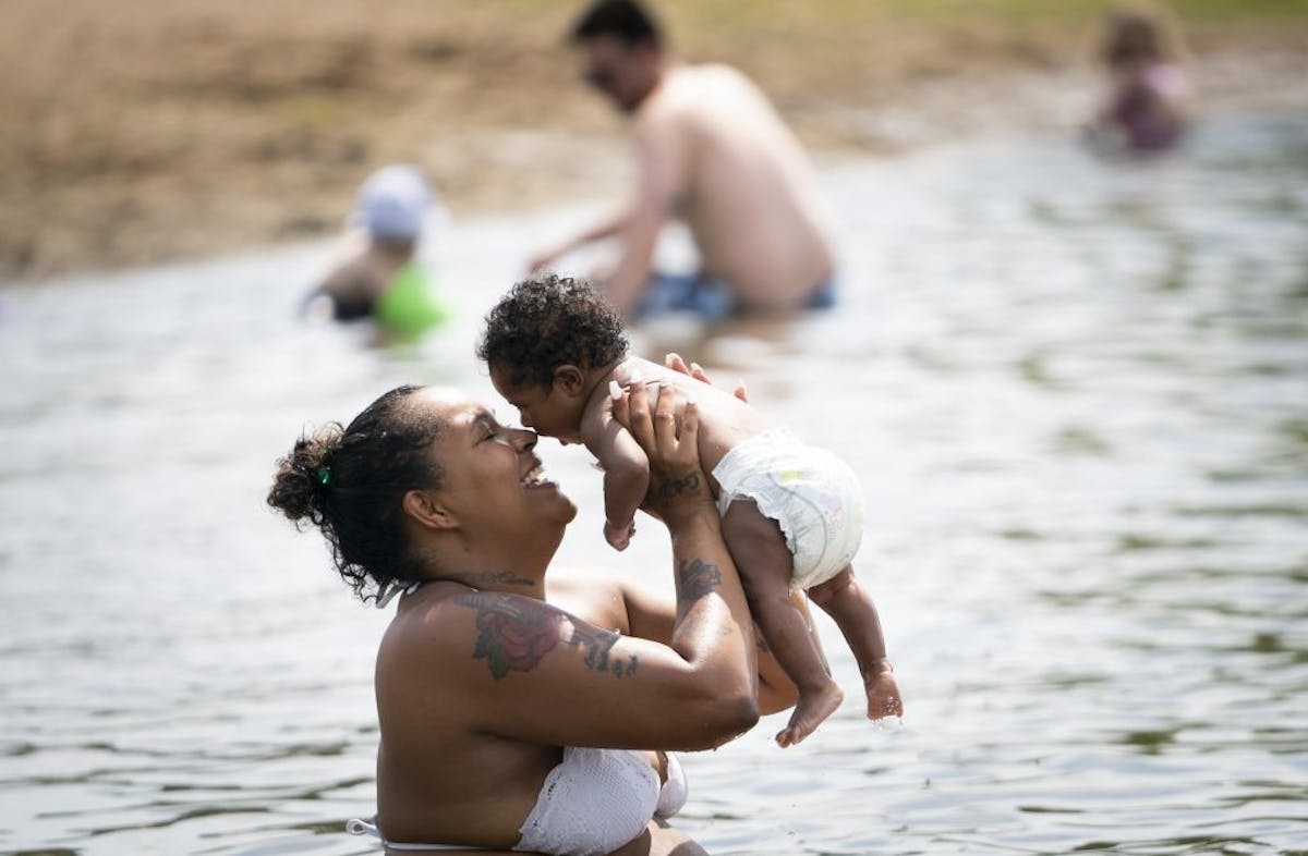 Erica Perkins took her 3-month old baby China Perkins for her first swim in Wirth Lake at Theodore Wirth Regional Park beach on Friday.