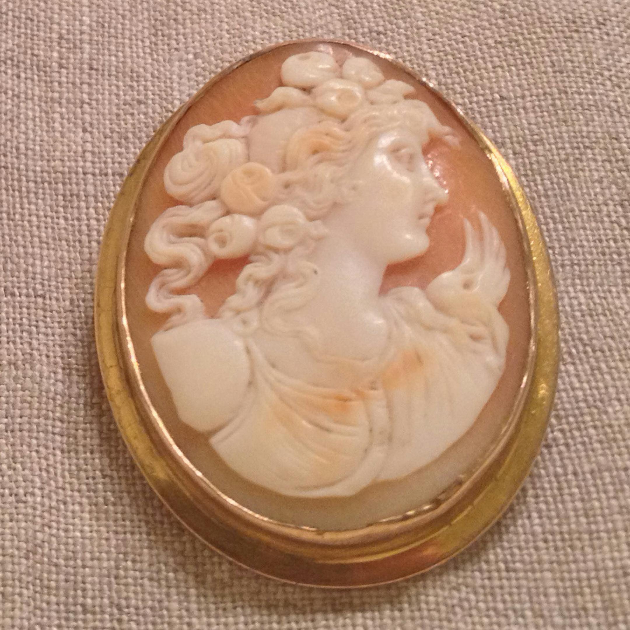 The cameo brooch that Grant Wood's sister Nan wears in "American Gothic" is displayed with other items - his glasses and cigarette box and a Christmas-ornament self-portrait - acquired by the Figge Art Museum in Davenport after she died in 1990. (Photo by Terry Robe, special to the Star Tribune)