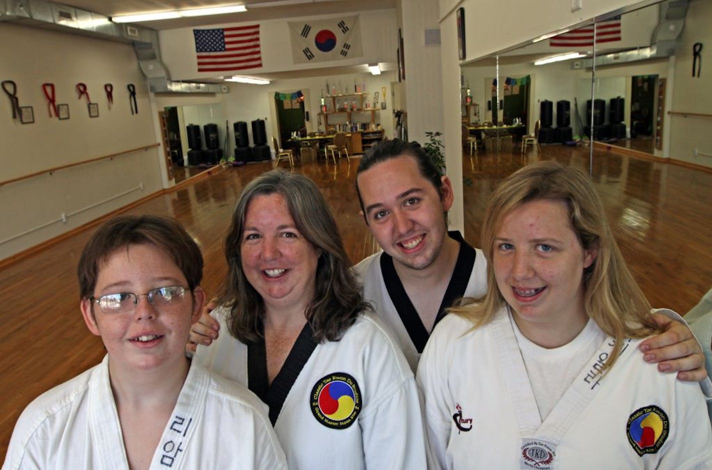 Carolyn Boston, second from left, owns the Classic TaeKwonDo Studios in Minneapolis and had her three kids -- from left, Liam, 13, Jarydd, 20, and Mikaela, 17 -- participate in the same activity to allow more family time.
