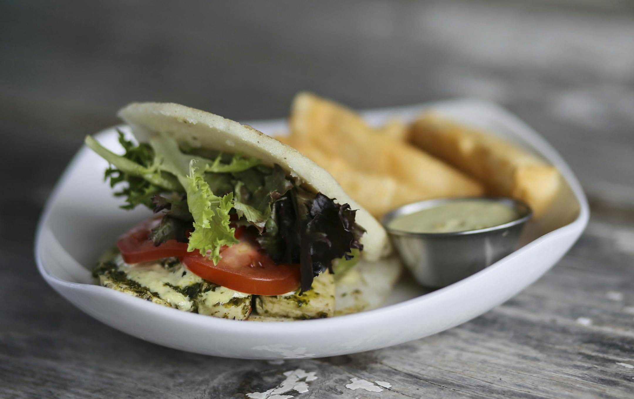 Hola Arepa, one of the city's great food trucks and now a restaurant, and chimichurri chicken arepas with tomato, chimichurri sauces, greens and aioli verde Friday, Sept. 12, 2014, in Minneapolis, MN.