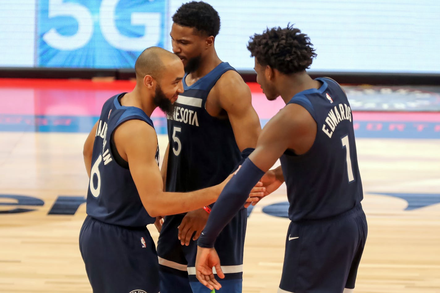 Minnesota Timberwolves' Jordan McLaughlin (6) is congratulated by teammates Malik Beasley (5) and Anthony Edwards after his late free throws during the second half of an NBA basketball game against the Toronto Raptors, Sunday, Feb. 14, 2021, in Tampa, Fla. (AP Photo/Mike Carlson)