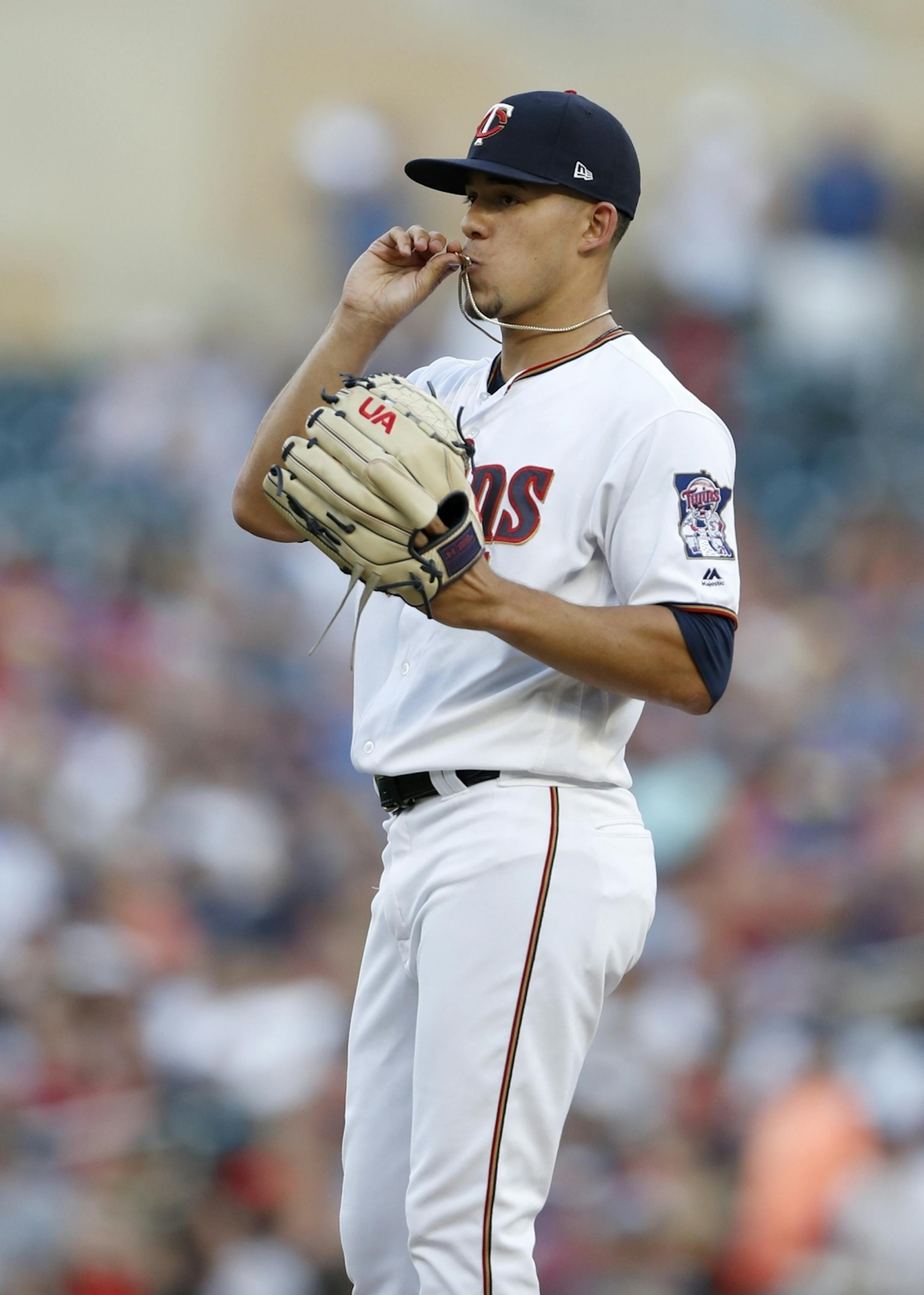 Minnesota Twins starting pitcher Jose Berrios (17) kissed his necklace before the start of the game.
