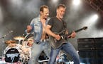 Eddie Van Halen, right, performs with David Lee Roth during a Van Halen concert.