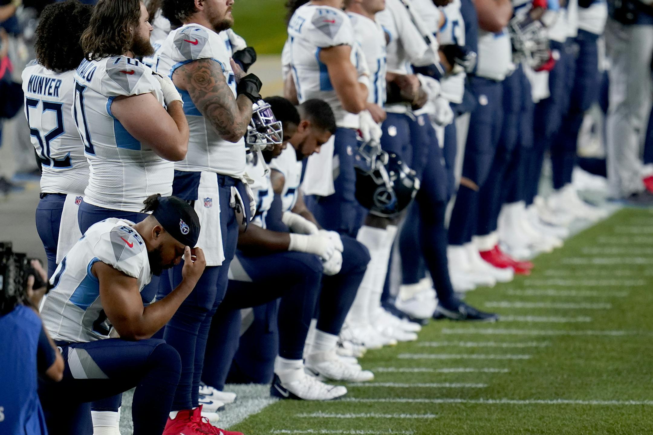 Some of the Tennessee Titans kneel during the national anthem prior to an NFL football game against the Denver Broncos, Monday, Sept. 14, 2020, in Denver. (AP Photo/Jack Dempsey)