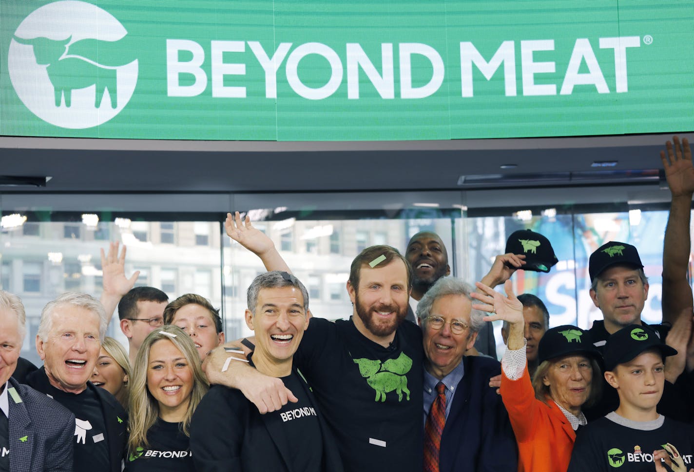 Ethan Brown, center, CEO of Beyond Meat, attends the Opening Bell ceremony with guests to celebrate the company's IPO at Nasdaq, Thursday, May 2, 2019 in New York. California-based Beyond Meat makes burgers and sausages out of pea protein and other ingredients. (AP Photo/Mark Lennihan) ORG XMIT: NYML103