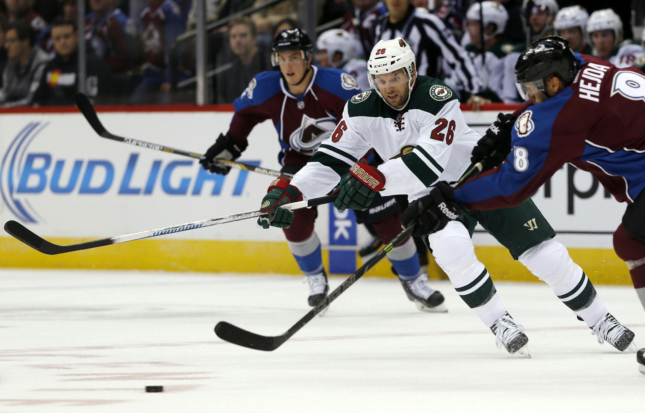 Minnesota Wild left wing Thomas Vanek, back, of Austria, pursues the puck as Colorado Avalanche defenseman Jan Hejda, of the Czech Republic, sends a pass down the ice in the first period of a hockey game in Denver on Saturday, Oct. 11, 2014. (AP Photo/David Zalubowski) ORG XMIT: MIN2014101122530447