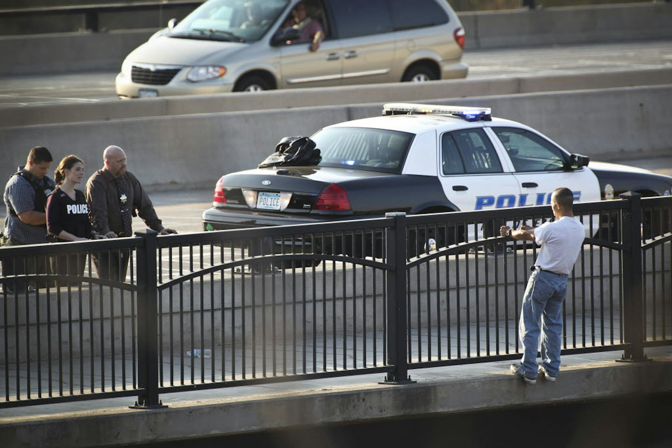 Police negotiators talked to a man, right, who threatened to jump from the Interstate 35E bridge over the Mississippi River on Tuesday.
