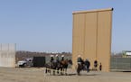 Border Patrol on horses stop by while testing is underway of a border wall prototype on Dec. 1, 2017 in Tijuana, Mexico. (Alejandro Tamayo/San Diego U