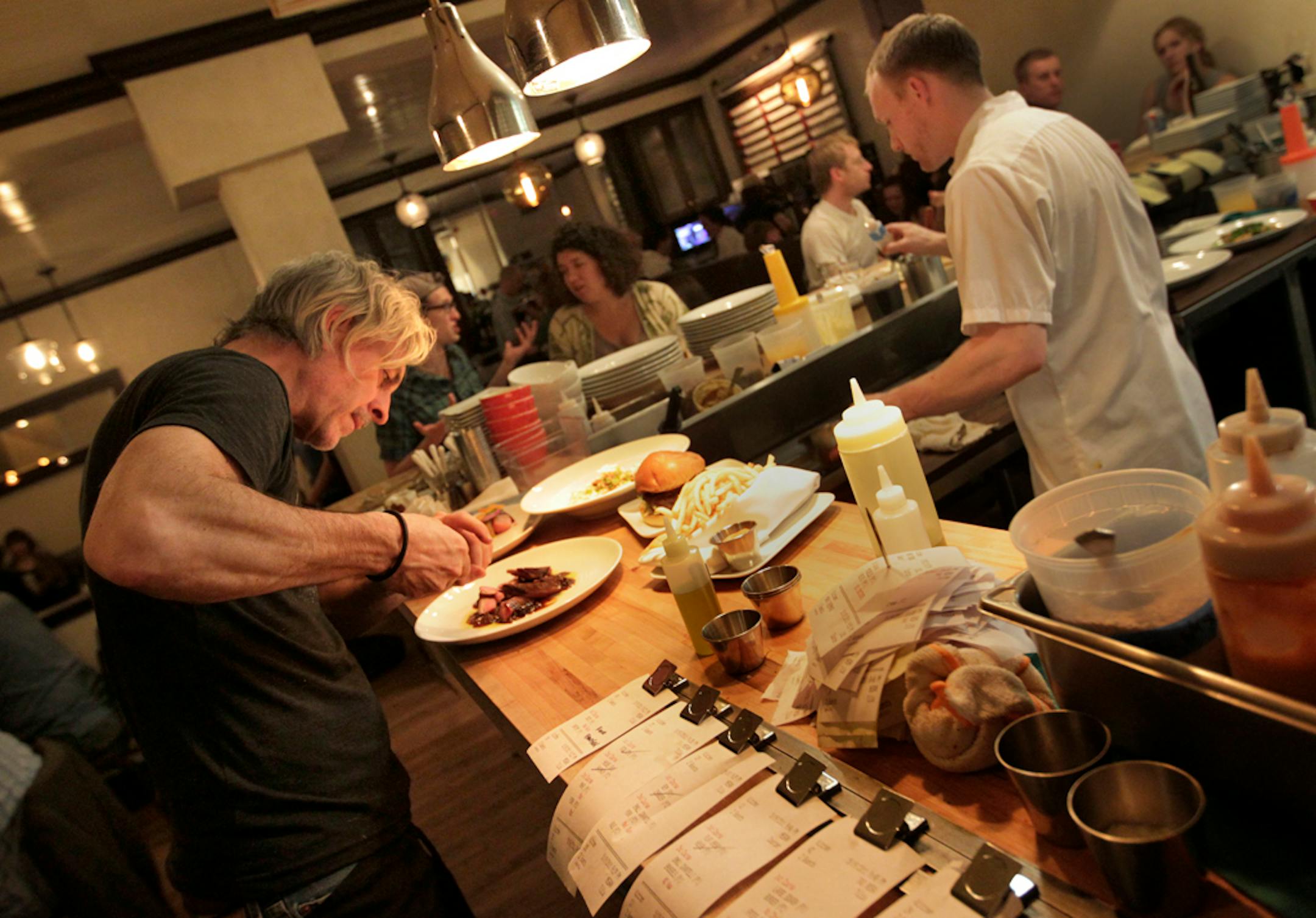 Tilia owner Steven Brown finishes off a dish before sending it out.