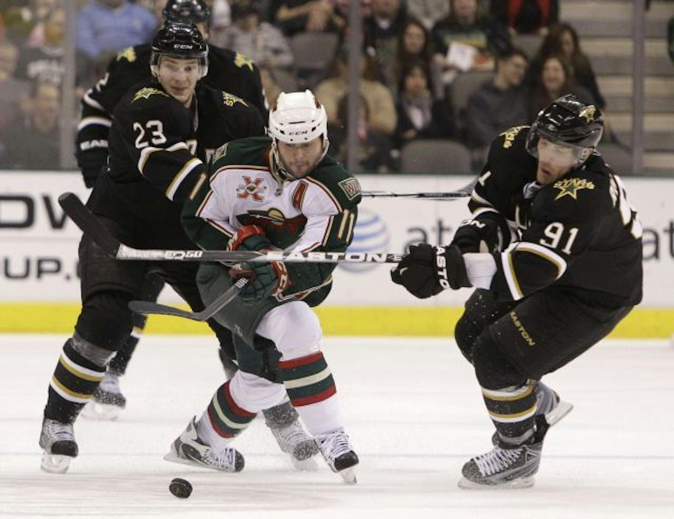 Dallas Stars' Brad Richards (91) and Tom Wandell (23) of Sweden challenge Minnesota Wild's John Madden for control of the puck in the third period of an NHL hockey game Friday, March 11, 2011, in Dallas. The Stars defeated the Wild, 4-0.