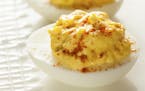 The traditional deviled egg, a favorite at any potluck gathering, is often topped with a sprinkle of paprika.