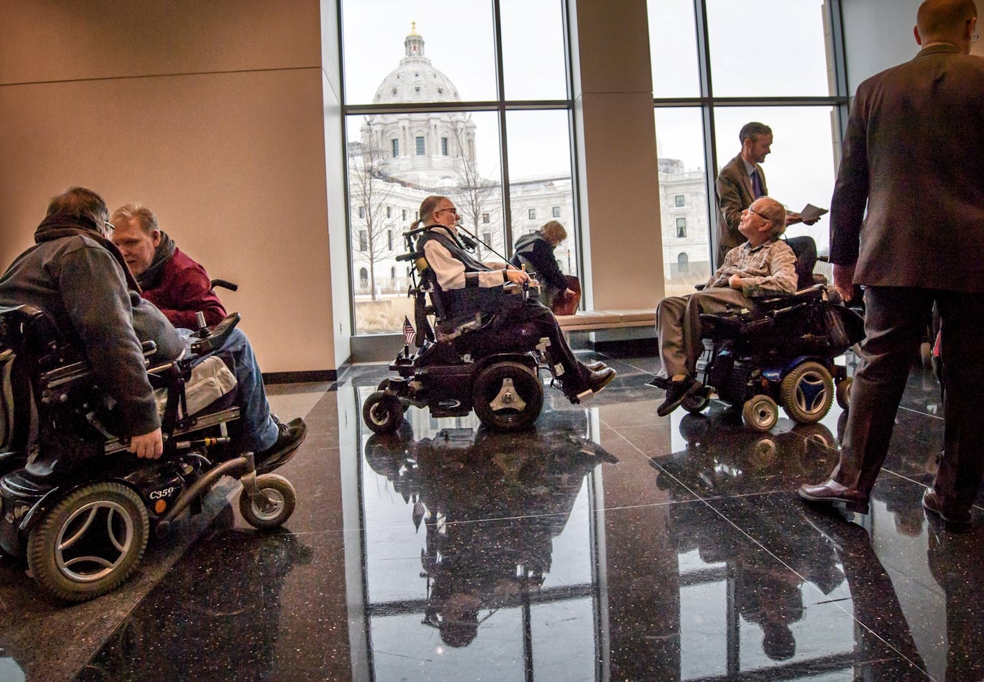 Wheelchair users Tim Benjamin, Jeff Bangsberg, Don Bania, and Jim Carlisle gathered after attending a hearing at the Capitol for bill that would help with the shortage of personal care assistants for people with disabilities.