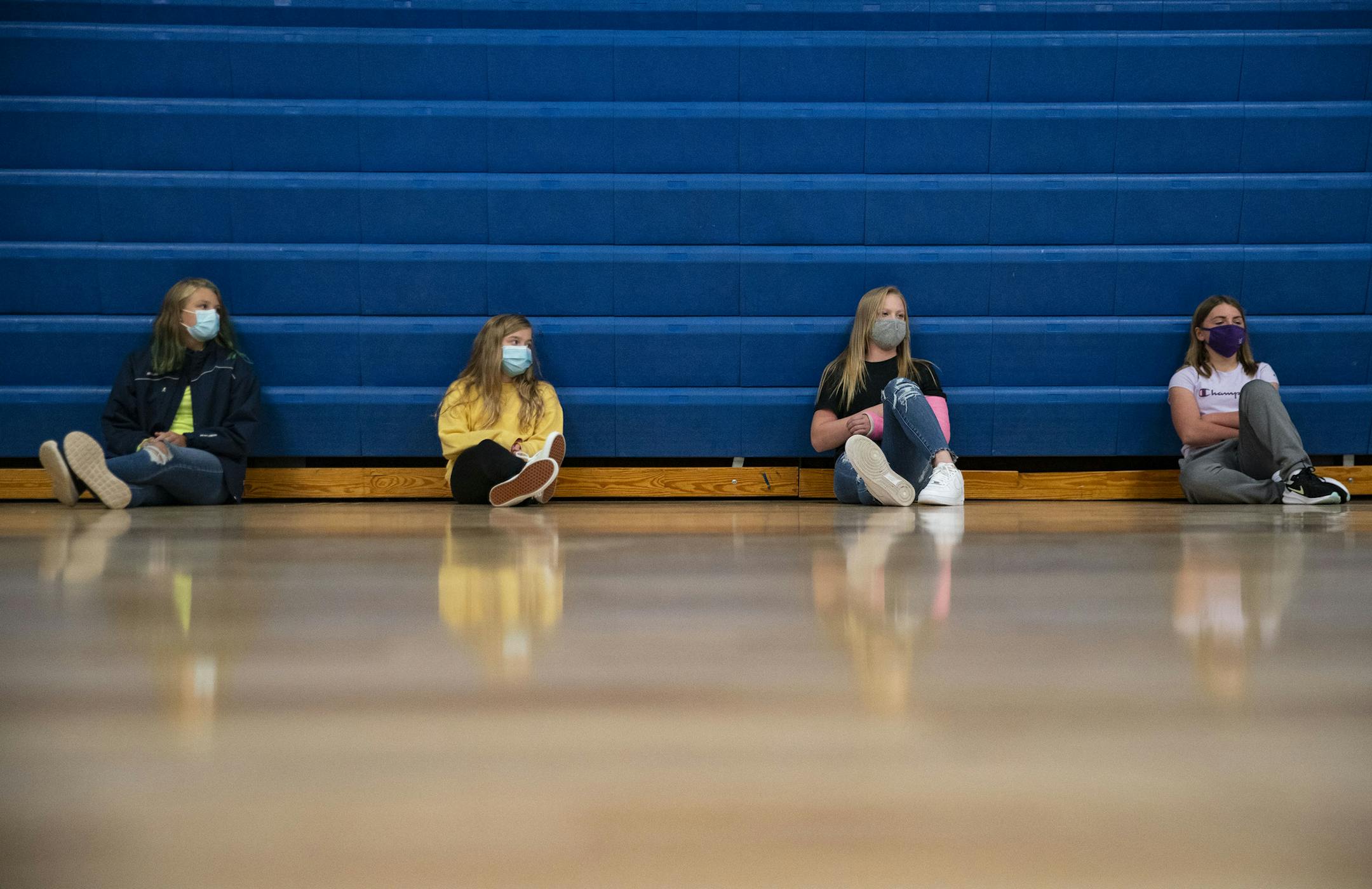(From left) Harper Carlson, Addison Erickson, Jaycee McMillan and Carley Lawry, all seventh grade students, listened to their teacher during gym class while maintaining social distancing in the Carlton High School gymnasium on Tuesday. ] ALEX KORMANN • alex.kormann@startribune.com Carlton High School held their day of school in-person on Tuesday September 8, 2020. Students and staff were required to wear masks and maintain social distancing in classrooms and the halls. Carlton will be in-person