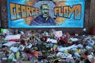Candles glow as dawn breaks near a mural for George Floyd at 38th Street and Chicago Avenue South in Minneapolis in 2020. 