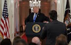 President Donald Trump listens to a question from CNN journalist Jim Acosta during a news conference in the East Room of the White House, Wednesday, N