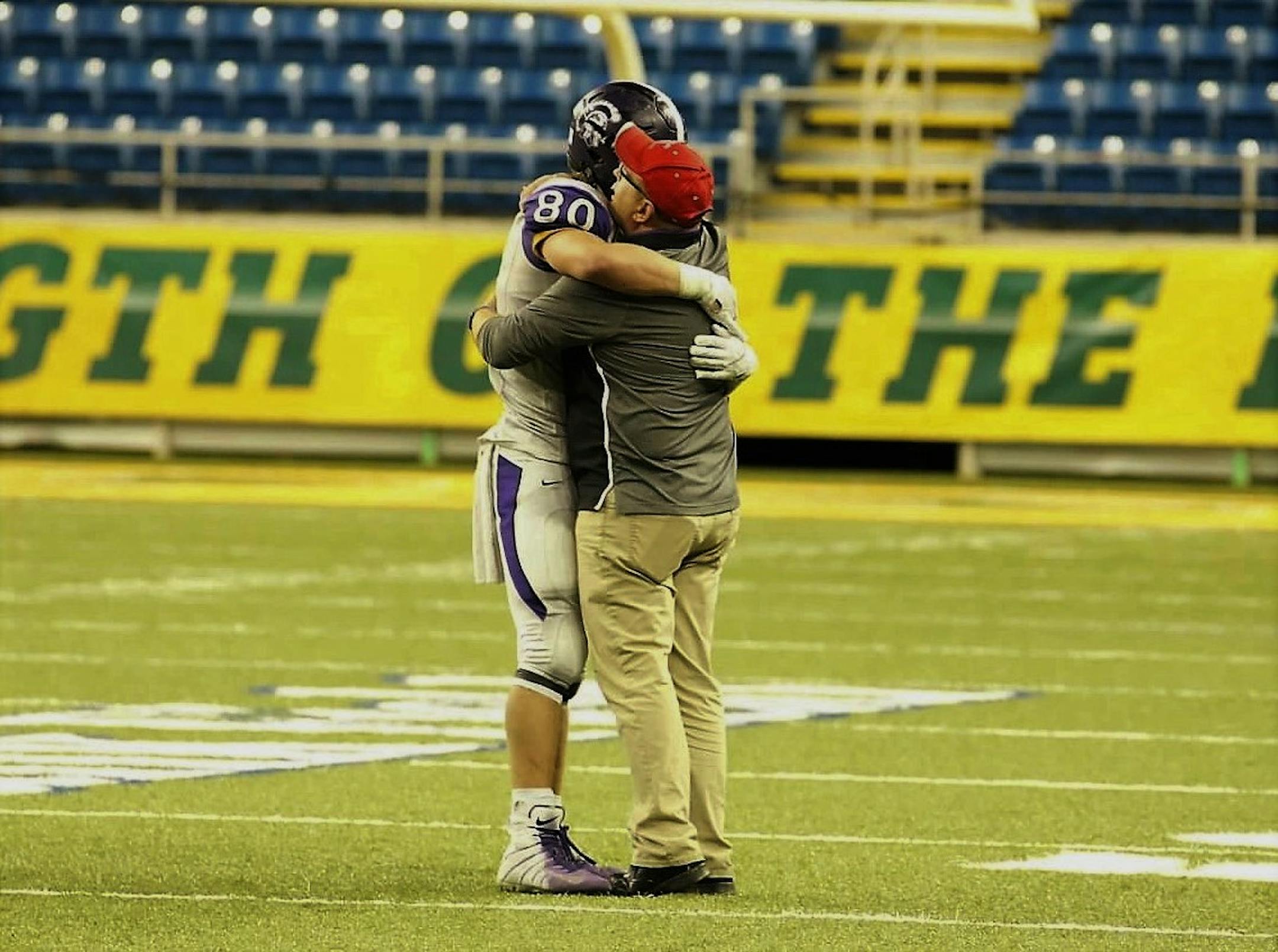Barnesville coach Bryan Strand embraces junior tight end/defensive end Hunter Zenzen after Barnesville defeated Hawley 34-23 in the Class 2A, Section 8 championship game at the Fargodome. Photo courtesy Holly Inninger