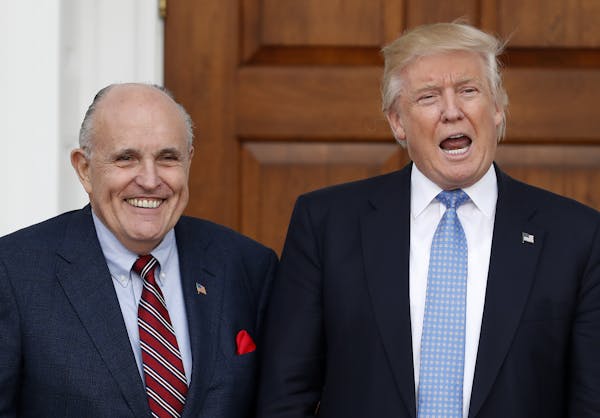 President-elect Donald Trump calls out to media as he and former New York Mayor Rudy Giuliani pose for photographs as Giuliani arrives at the Trump Na