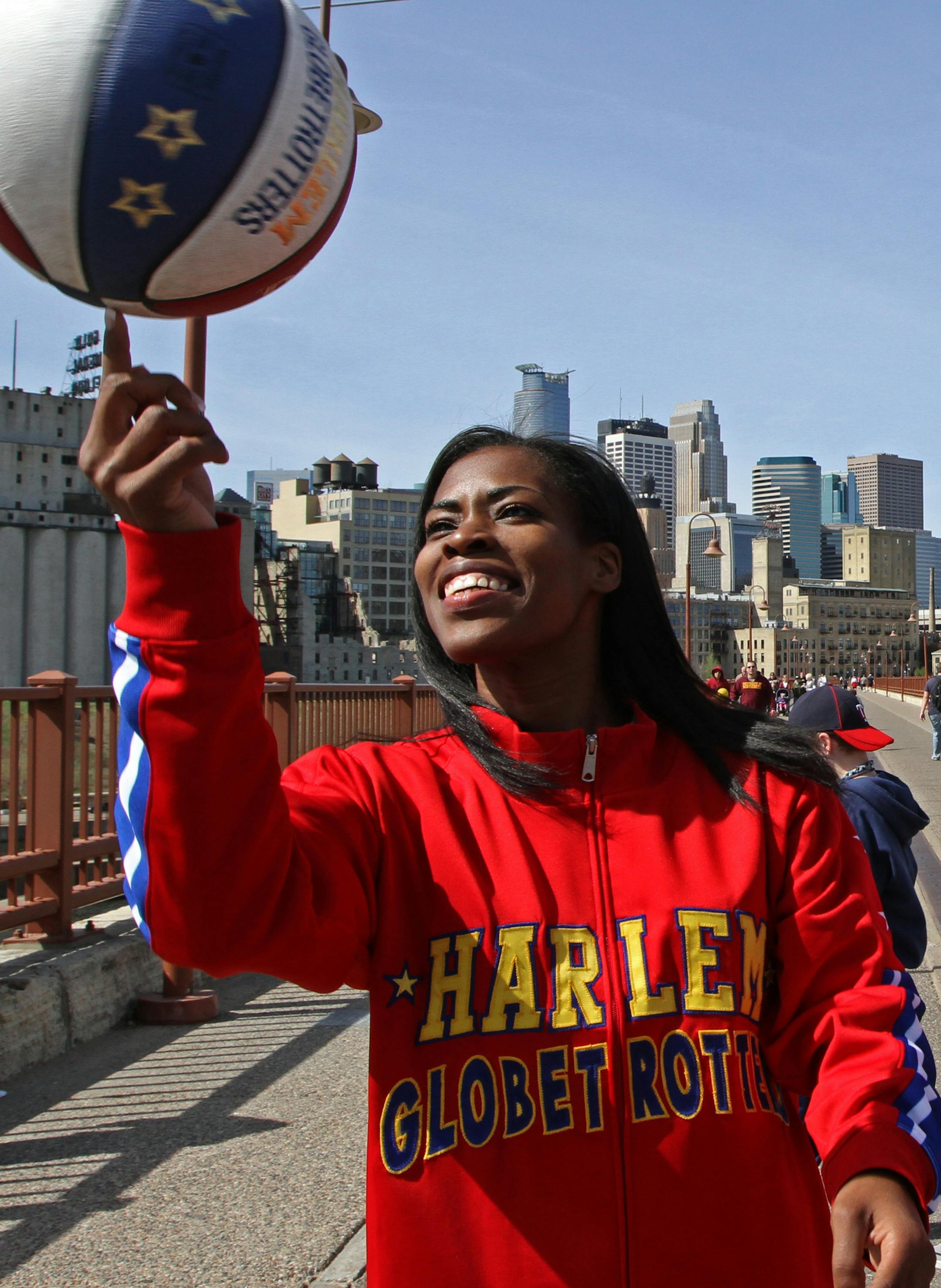 (left to right) Fatima "TNT" Maddox and Anthony "Buckets" Blakes of the Harlem Globetrotters spun the ball on their fingertips as they started to walk across the Stone Arch Bridge in downtown Minneapolis on 4/4/12. The two Globetrotters were in the city to preview the world famous groups appearance this Friday and Saturday at the Target Center. Rookie player Maddox is the first female on the team in 19 years and only the 9th female player in Globetrotters history.] Bruce Bisping/Star Tribune bbi