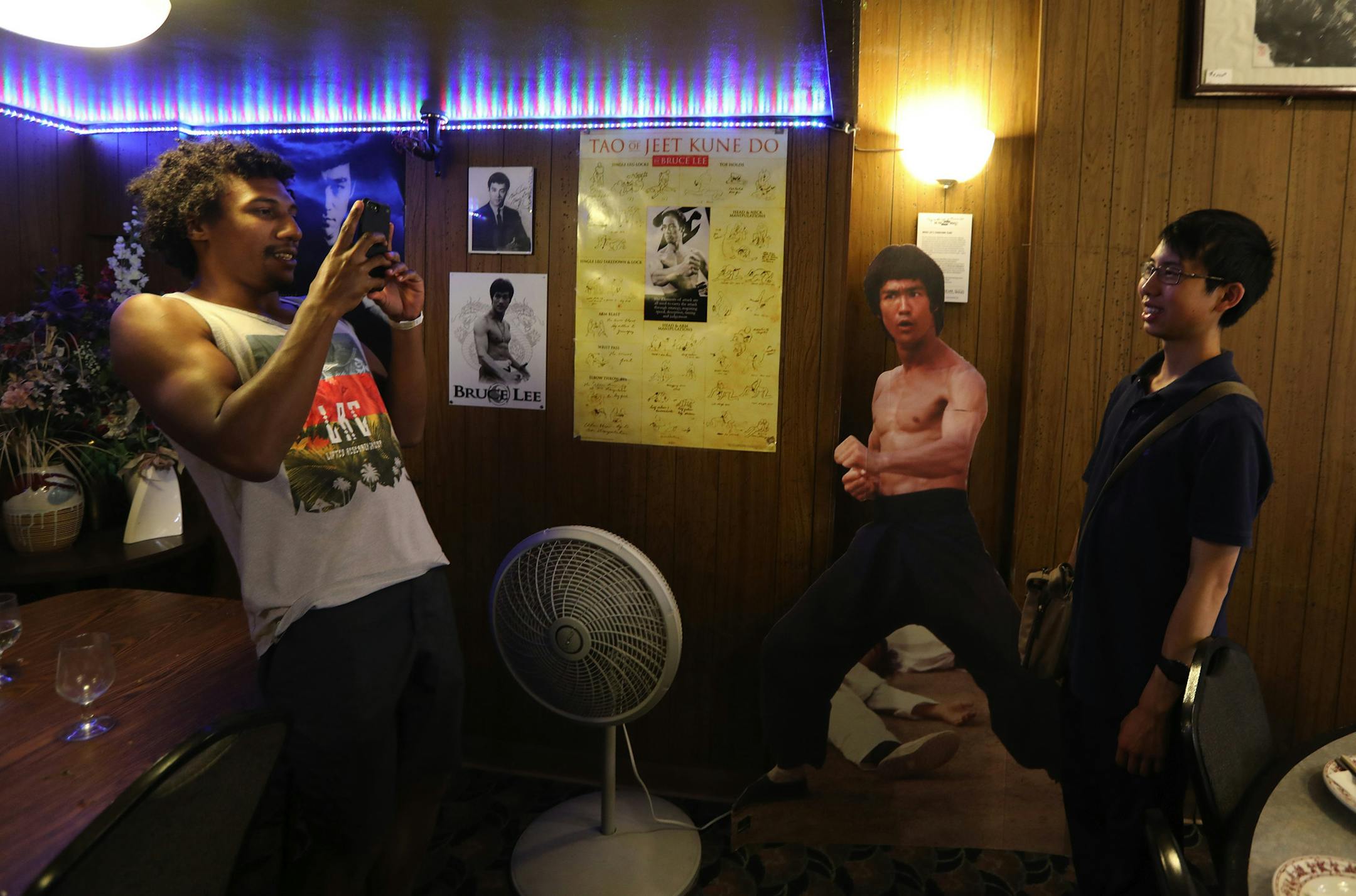 Josh DeVaughn, left, photographs Charles Liang in Tai Tung restaurant where Bruce Lee often ate. (Alan Berner/The Seattle Times/TNS)