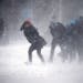 People struggle to walk in the blowing snow during a winter storm Tuesday, March 14, 2017, in Boston.