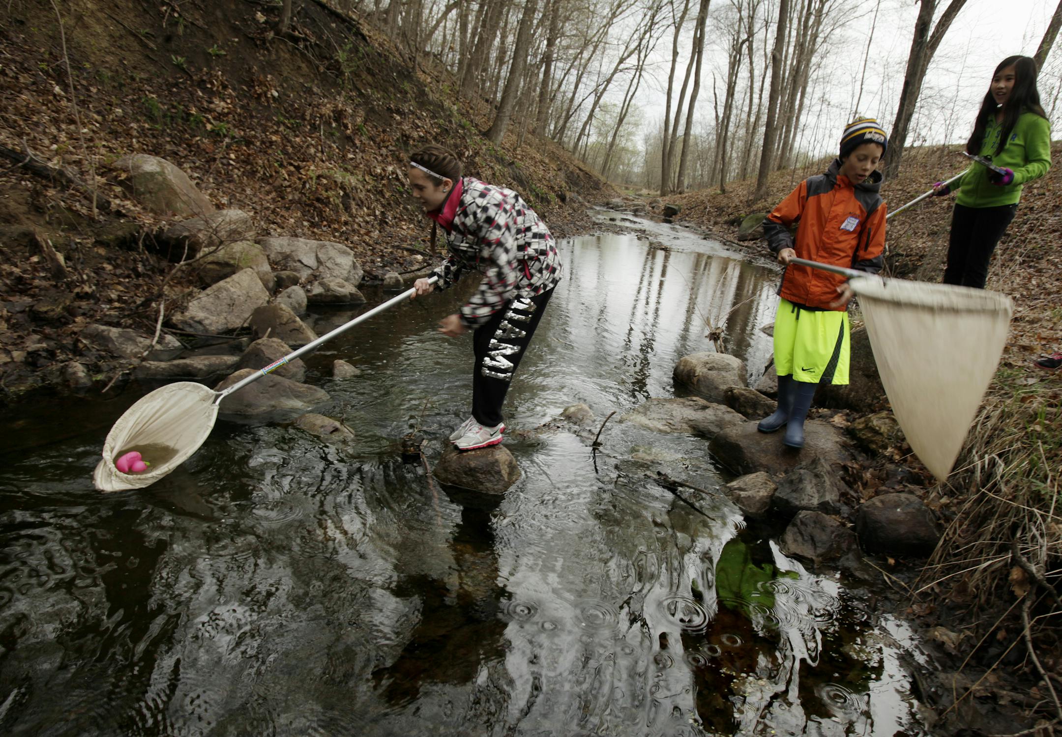 Left to right: Keely Heinrich (black and white jacket), Trey Forst Hilnerson (orange jacket, Lakers hat), and Lynh Tran (green), on an environmental experiment involving the velocity of the stream at Jeffers Pond Elementary in Prior Lake, MN on May 9, 2013. ] JOELKOYAMA‚Ä¢joel koyama@startribune.com MAGIC SAXO NUMBER IS 644715 The Prior Lake-Savage district was one of 14 districts to win the national Green Ribbon Schools award given by the U.S. Department of Education last month