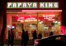 Papaya King, at the head of St. Marks Place, glows with neon. Located across the street from St.