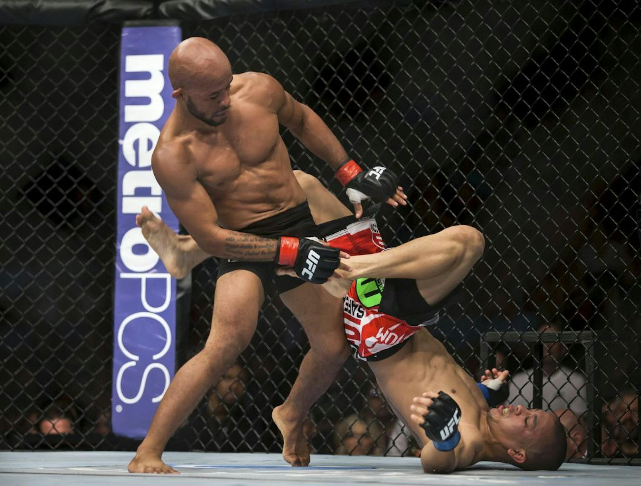 UFC flyweight champion Demetrious Johnson, left, fights John Moraga during their bout Saturday, July 27, 2013, in Seattle. Johnson defended his title with a submission victory.