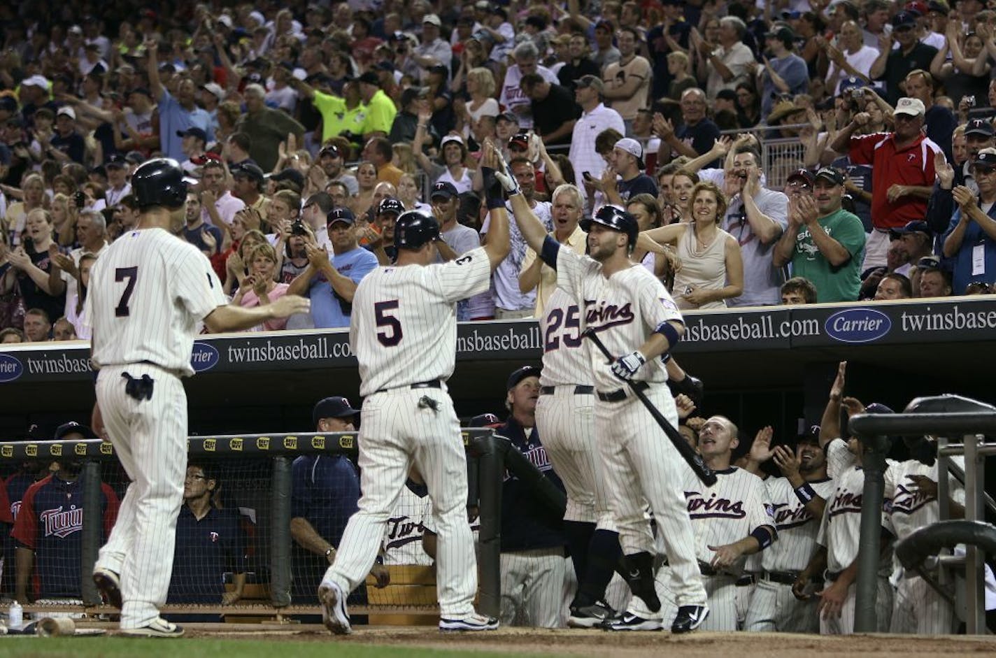 Twins Rene Tosoni hi fives Jim Thome, Michaal Cuddyer and Joe Mauer after Thome hit a 3 run homerun in the first inning at Target Field in Minneapolis, Minn. Friday, July 1, 2011.