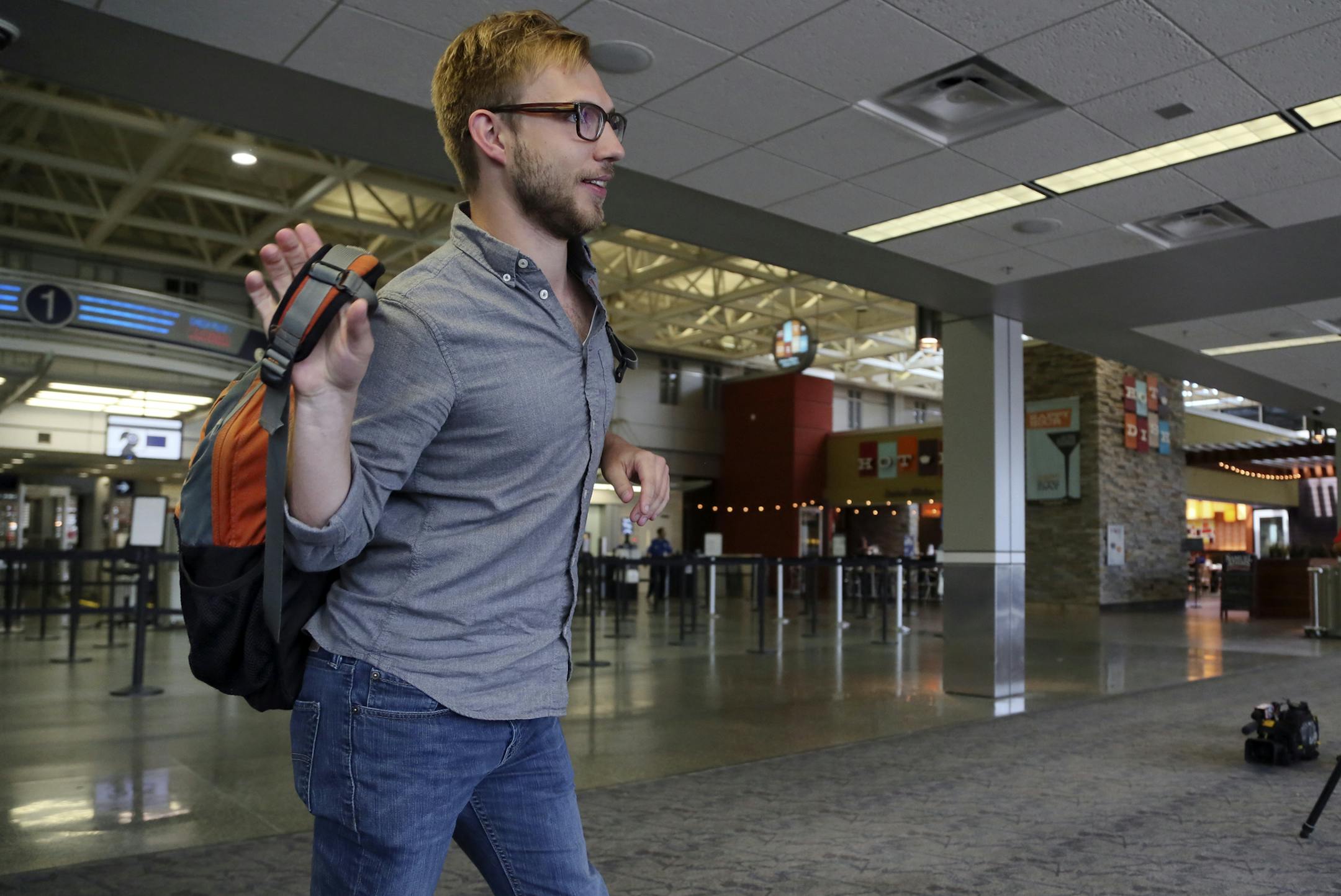 Nicholas Vangen-Weeks, 24, who works for the Minneapolis-based American Refugee Committee, puts on a backpack as members of the local TV media wait to interview him Tuesday, Sept. 3, 2013 at MSP International Airport, in Bloomington, MN. Vangen-Weeks was headed to Jordan to help support ARC's efforts to prepare for the large influxes of Syrian refugees, crossing into Jordan.](DAVID JOLES/STARTRIBUNE) djoles@startribune.com Nicholas Vangen-Weeks of Minneapolis departs for Jordan to help people wh