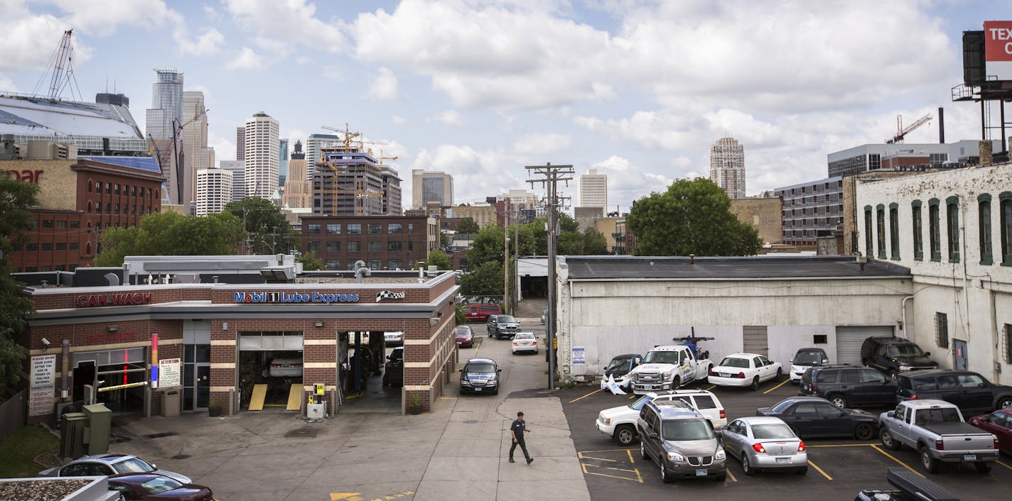 Cars drive to and from 12th Avenue South at Bobby and Steve's Auto World on Friday, August 7, 2015. The owners of Bobby and Steve's Auto World would like to demolish the white building on the right to give more room for cars to drive in and out from 12th Avenue South, which is not currently wide enough for two cars to pass each other. ] LEILA NAVIDI leila.navidi@startribune.com / BACKGROUND INFORMATION: Friday, August 7, 2015.The most prominent gas station near downtown Minneapolis wants to make