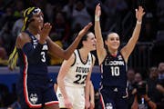 Iowa's Caitlin Clark (22) celebrates as UConn's Aaliyah Edwards (3) reacts after she was called for an illegal screen in the final seconds of the Iowa