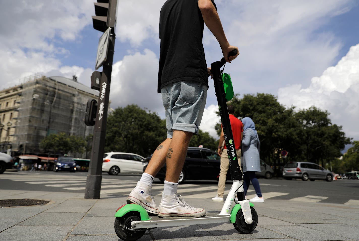 A man rides an electric scooter in Paris, Monday, Aug. 12, 2019. The French government is meeting with people who've been injured by electric scooters as it readies restrictions on vehicles that are transforming the Paris cityscape. The Transport Ministry says Monday's closed-door meeting is part of consultations aimed at limiting scooter speeds and where users can ride and park them. (AP Photo/Lewis Joly)