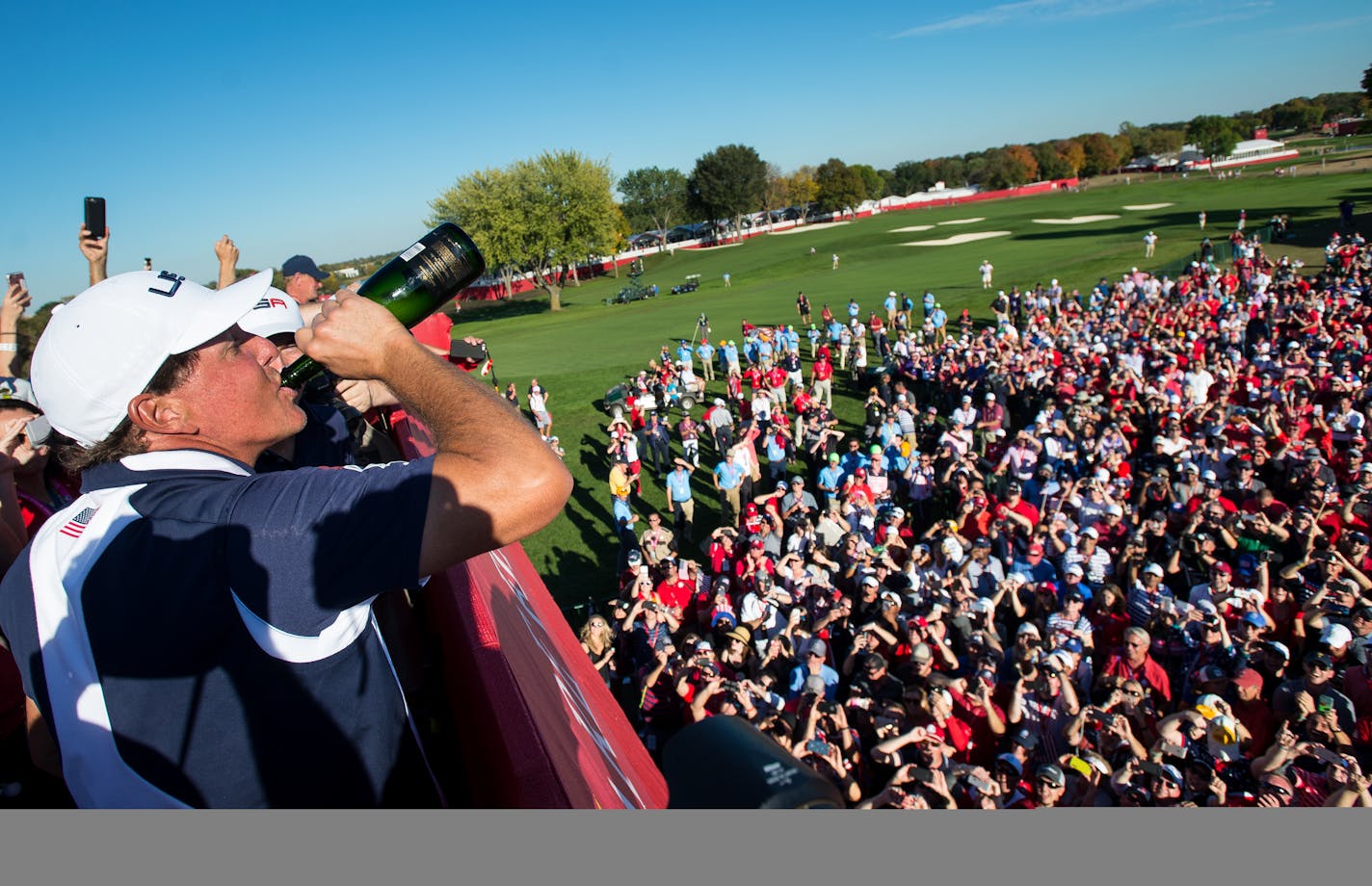 Phil Mickelson drinks from a bottle of champagne while celebrating Team USA's Ryder Cup victory over Europe in 2016.