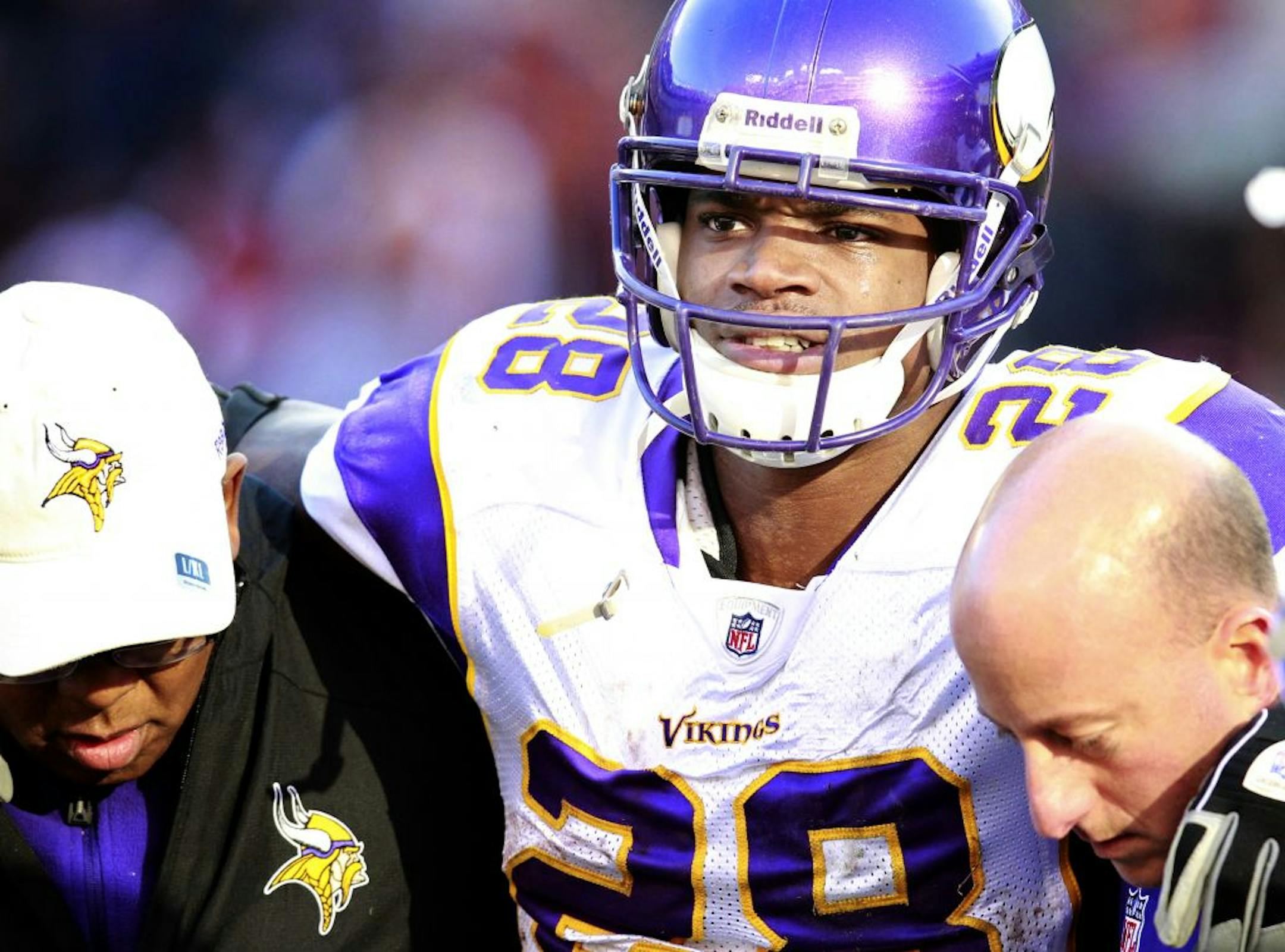 Adrian Peterson (28) was assisted off the field after injuring his knee in the third quarter.