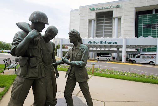 FILE - In this June 9, 2014 file photo is a sculpture portraying a wounded soldier being helped on the grounds of the Minneapolis VA Hospital. Minnesota&#x2019;s Veterans Affairs clinics and hospitals fare slightly better in delivering timely care to veterans than the national average between September and February, according to six months of appointment data analyzed by the Associated Press. (AP Photo/Jim Mone, File) ORG XMIT: MIN2015051314130372 ORG XMIT: MIN1505131416040110