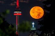The super blue moon set behind the CN tower in Toronto on Wednesday. The cosmic curtain rises Wednesday night with the second full moon of the month, 