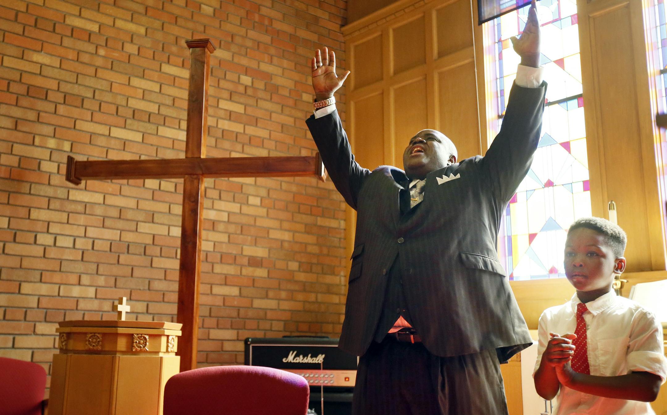 Genadrick Davis 5 stood next to his pastor Harding Smith who is pastor at Spiritual Church of God during worship services Sunday April 12, 2015 in Robbinsdale, Minnesota. Pastor Smith to talked to his congregation about Barway Collins the 10 year-old whoís body was found Saturday in the Mississippi River in Brooklyn Center. Jerry Holt/ Jerry.Holt@Startribune.com